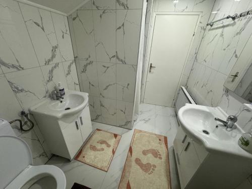 a white bathroom with a sink and a toilet at Apartment Alisha in Cazin