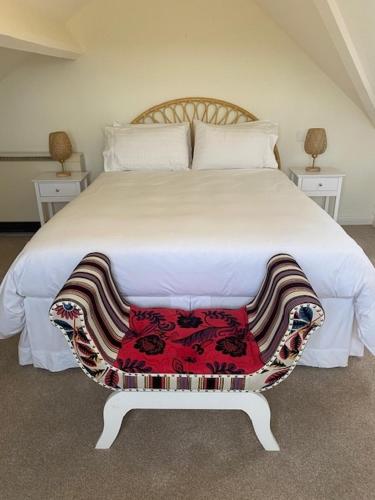 a bedroom with a large white bed with two tables at Newton House Apartment, Newton Burgoland in Heather