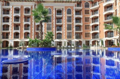 a hotel with a pool in front of a building at Ravda Cascadas in Ravda