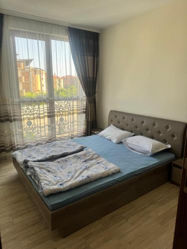 a bed in a bedroom with a large window at Ravda Cascadas in Ravda