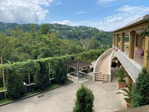 an outdoor patio with a bridge and a gazebo at Giorgi's Guesthouse in K'obulet'i