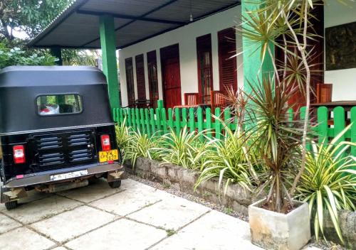 a truck parked in front of a house with a palm tree at Jm Resort in Dambulla