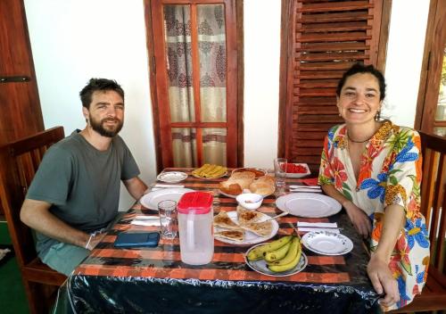 a man and a woman sitting at a table with food at Jm Resort in Dambulla