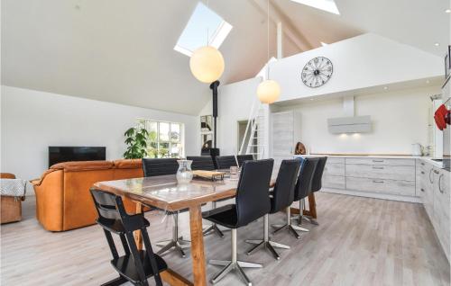 a kitchen and dining room with a wooden table and chairs at Luna in Vedelshave