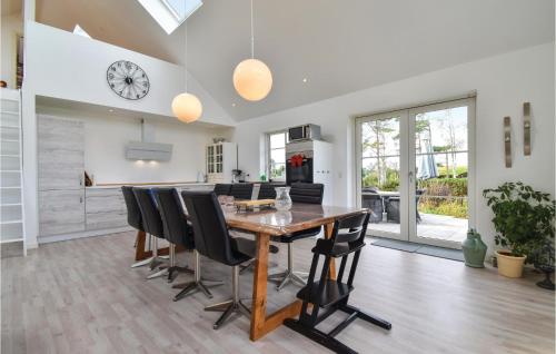 a kitchen and dining room with a wooden table and chairs at Luna in Vedelshave