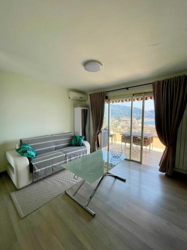 un salon avec un canapé et une table en verre dans l'établissement RocaMare - entre Monaco et Menton, près des plages, à Roquebrune-Cap-Martin