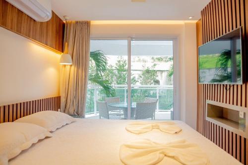 a bedroom with a large bed and a balcony at In Mare Bali Resort Beira Mar em Cotovelo by Qavi in Granja Beira Mar