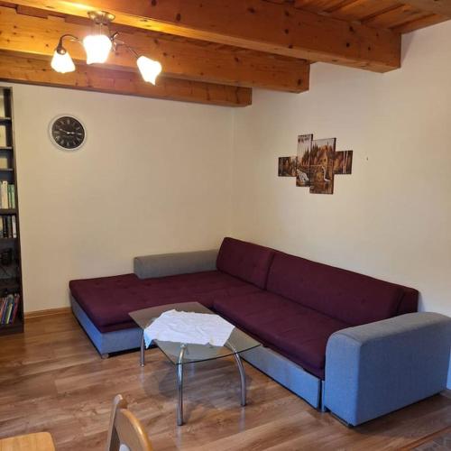 a living room with a purple couch and a table at Dom na prenájom v Terchovej in Žilina
