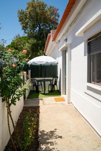 a table with an umbrella in the backyard of a house at Front House in Lisbon