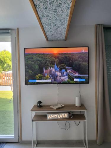un téléviseur à écran plat accroché au mur dans l'établissement Au cœur de la nature Le cerf, à Saint-Vincent-Jalmoutiers