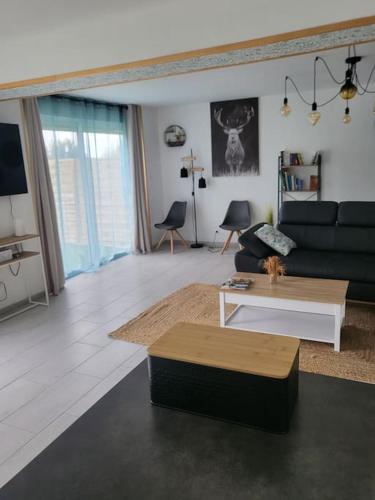 un salon avec un canapé et une table basse dans l'établissement Au cœur de la nature Le cerf, à Saint-Vincent-Jalmoutiers