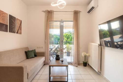 a living room with a couch and a table at Family Friendly Luxury Apartment in Néa Alikarnassós