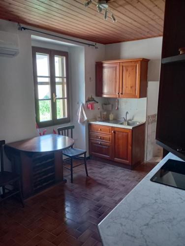 a kitchen with wooden cabinets and a table and a window at Tabernacolo in Carpineta