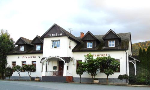 a white building with a black roof at Toris Inn in Třinec