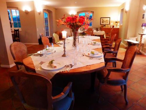 a dining room table with a vase of flowers on it at Liszkay Borkúria in Monoszló