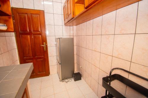 a kitchen with a small refrigerator in the corner at Immeuble rose in Douala