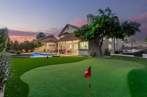 a golf course with a red flag in front of a house at Elegant Luxury Villa Wheated Pool Outdoor Fun in Chandler
