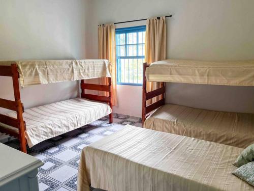 a room with three bunk beds and a window at Casa Acuri in Jacareí