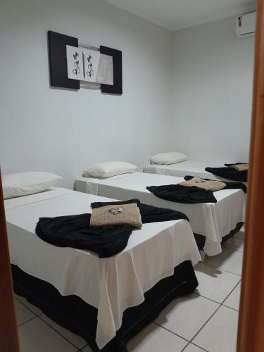 a group of beds lined up in a room at HOTEL POUSADA SÃO PEDRO MATÃO in Matão