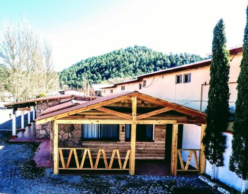 a house with a wooden pavilion in front of it at Parador del Alma in Creel