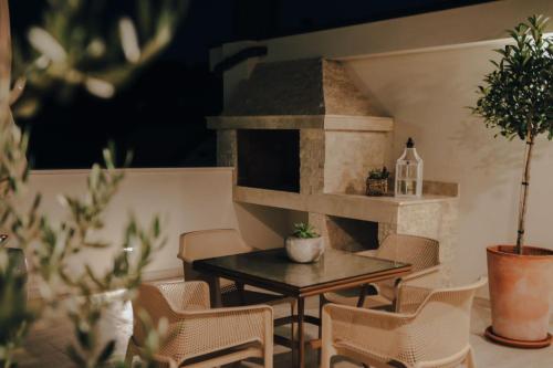 ČitlukにあるWine Apartment Brkicのピザオーブン付きの客室で、テーブルと椅子が備わります。