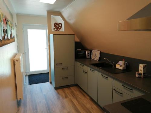a kitchen with a sink and a refrigerator at May Home in Schashagen