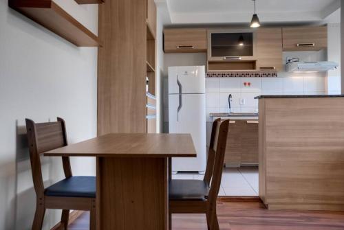 a kitchen with a wooden table and a white refrigerator at Flex Carapicuiba 2 Quartos Econômico Completo in Carapicuíba