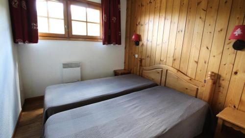 une chambre avec un lit dans une pièce en bois dans l'établissement Résidence Dame Blanche - DBAC14 - APPT 2 CHAMBRES - BALCON - 6 PERSONNES - Secteur 1800 MAE-4221, à Narreyroux