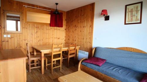 un salon avec une table et un canapé bleu dans l'établissement Résidence Dame Blanche - DBA106 - APPT 1 CHAMBRE + CABINE - BALCON - 6 PERSONNES MAE-4211, à Narreyroux