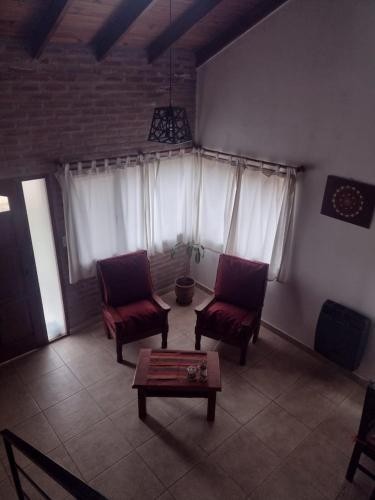 a living room with two chairs and a coffee table at Atardecer Serrano in Villa General Belgrano