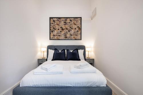 a bedroom with a white bed with two pillows at Kensington 1bd apt seconds from Museums in London