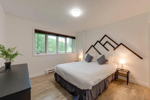 a bedroom with a large bed and a window at La Crête 65 - 3 chambres - 6 personnes in Saint-Férréol-les-Neiges