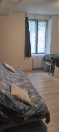 une chambre avec un lit, une table et des fenêtres dans l'établissement Superbe appartement en plein centre ville, à Viarmes