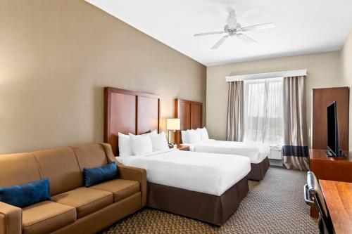 una camera d'albergo con due letti e un divano di Comfort Inn & Suites Grenada a Grenada