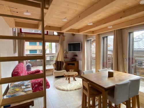 - un salon avec une table en bois et une salle à manger dans l'établissement Appartement HYPERCENTRE Les Gets, aux Gets