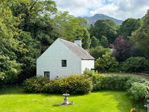 a white house in the middle of a yard at The Bothy of Ballachulish House in Ballachulish