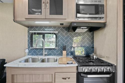 a kitchen with a sink and a stove at Cozy Rv Retreat Fast Wi-fi & Pet-friendly in Orlando