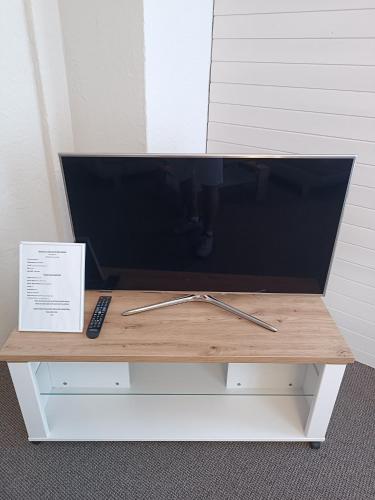 a television on a table with a remote control on it at Mon Amour Apartment in Interlaken