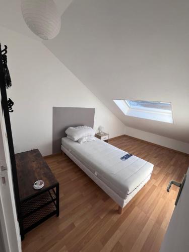 - une chambre blanche avec un lit et une lucarne dans l'établissement Gîtes des travailleurs et estivants, à Grand-Fort-Philippe