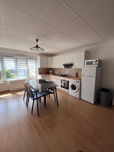 une cuisine avec une table et des chaises dans une pièce dans l'établissement Gîtes des travailleurs et estivants, à Grand-Fort-Philippe