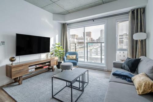 a living room with a couch and a tv at 1CH - Rooftop pool - Kitchen - Smart TV - Gym - 750m QC in Quebec City