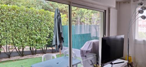 a living room with a television and an umbrella at Appart Chatou in Chatou