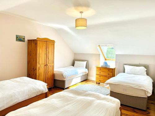 a bedroom with two beds and a dresser at No's 6, 8 & 9 Dingle Lispole Holiday Homes in Lispole