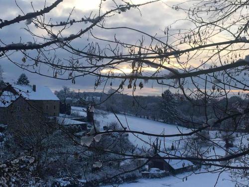 a winter view of a river with snow on the ground at Ferme de Filot in Filot