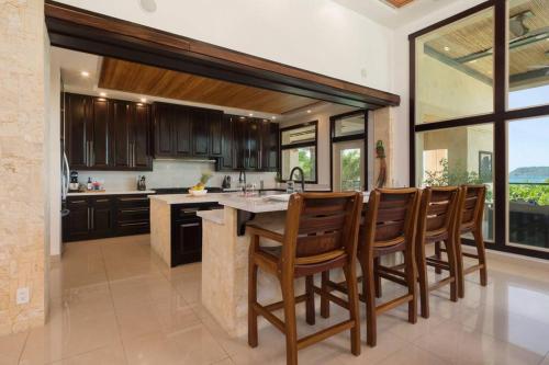 a kitchen with a island with a bunch of chairs at Villa Oceano in Potrero