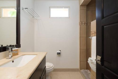 a white bathroom with a sink and a toilet at Villa Oceano in Potrero