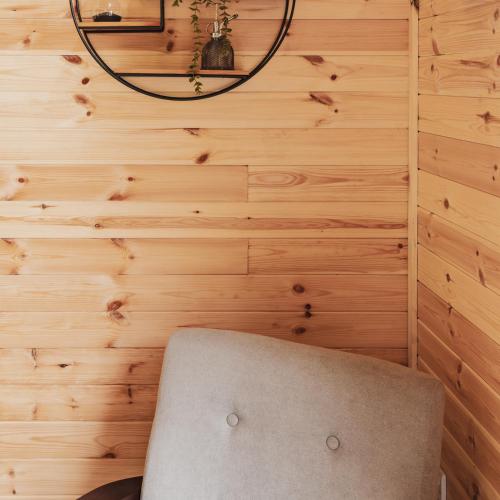 a room with a chair and wood paneling at The Tree Houses at Madeira in Fife in Pittenweem