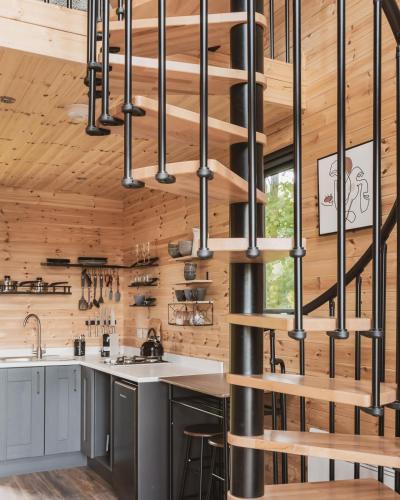 a kitchen with wooden walls and a spiral staircase at The Tree Houses at Madeira in Fife in Pittenweem