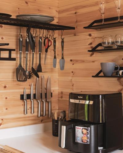 a kitchen with utensils hanging on a wall at The Tree Houses at Madeira in Fife in Pittenweem