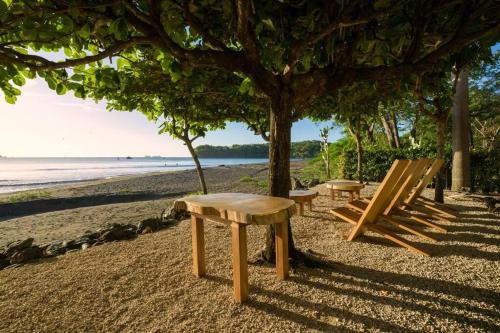 a bench and a table on the beach at Villa Oceano in Potrero